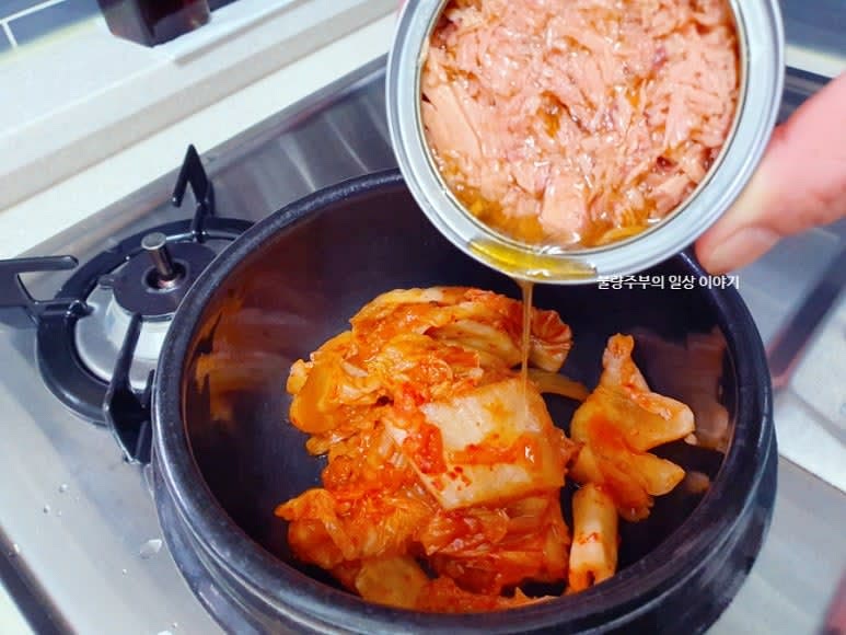뚝배기에 김치를 넣고 참치 기름에 중약불로 볶아줍니다. 고춧가루 0.5큰술을 넣어 칼칼한 맛을 더해줍니다.