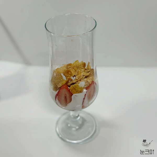 컵 아래 부분에 반으로 자른 딸기를 벽 쪽으로 빙 둘어서 넣어주고 바닐라 아이스크림을 한 스쿱 떠 넣어 준 뒤 시리얼을 올려줍니다.