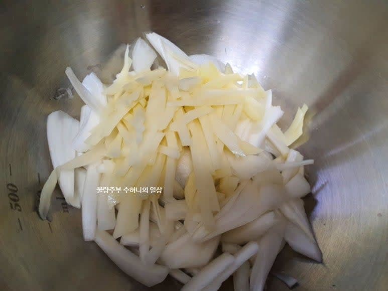 볼에 채썬 양파, 감자를 넣고 대파는 총총 썰어서 같이 넣어줍니다. 고춧가루를 추가해서 잘 섞어줍니다.
