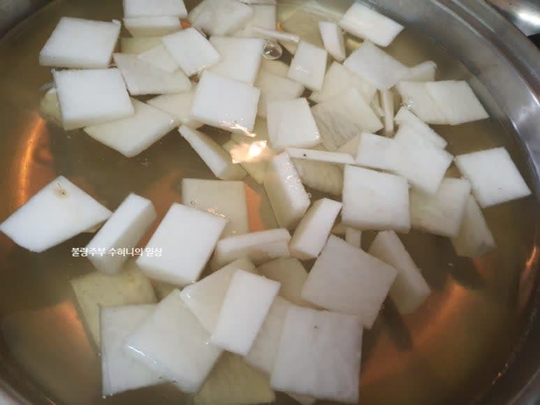 냄비에 육수, 쌀뜨물, 무, 마늘을 넣고 끓입니다.