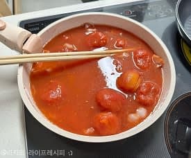 홀토마토 캔에다가 물을 담아 팬에 부어주고 토마토를 적당한 크기로 가위로 잘라주세요