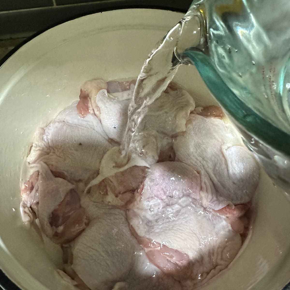 준비한 닭다리살을 냄비 바닥에 껍질이 위로 오도록 넣고 물과 청주를 부어 주세요.