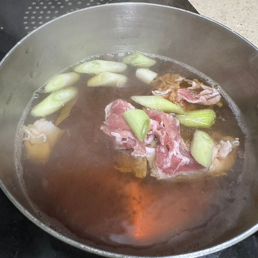 준비한 육수에 간장 맛술을 넣고 돼지고기랑 파 그리고 소금을 넣고 끓여주세요.