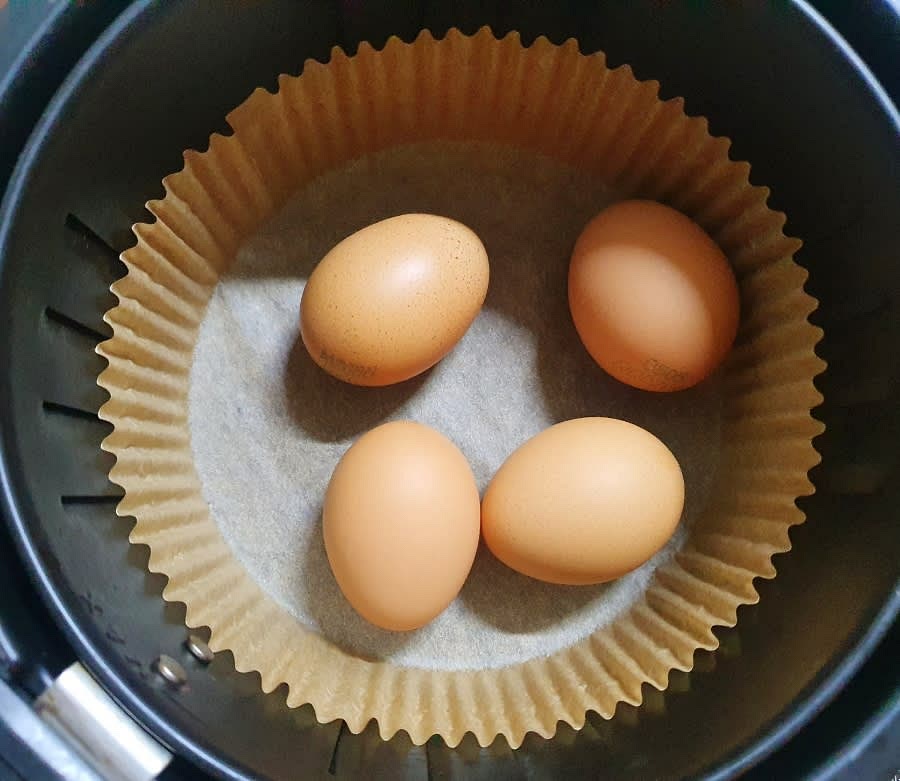 에어프라이어에 종이호일을 깔고 냉장고에서 바로 꺼낸 계란 4개를 넣어주세요. 계란은 3~5개 정도를 넣고 만드는게 좋은 것 같아요. 계란 양이 늘어나면 조리 시간도 더 늘려야 하니 참고해 주세요.