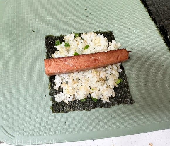 김밥 김을 4등분 해준 뒤에 김1쪽을 올려 잘 섞은 밥을 올려주고 스팸을 올려 돌돌 말아주세요