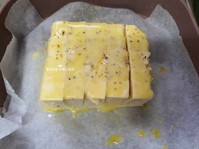 에어프라이어 용기에 종이호일을 깔아주고 두부 위에 트러플 오일을 뿌려줍니다.