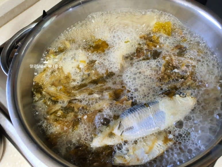 끓는 육수에 무쳐둔 시래기와 다진 마늘 1큰술을 넣고 잘 섞어준 후 한소끔 끓으면 불을 줄여 10분 정도 더 국물을 우려줍니다.