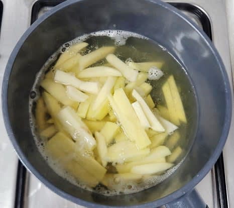 10분 후 다시팩을 제거하고, 준비한 감자를 육수에 넣어 중불에서 끓입니다. 감자가 반쯤 익으면 청양고추와 다진 마늘 1 큰술을 추가합니다.