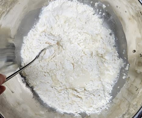 큰 볼에 부침가루 200그램을 넣고, 물 150밀리리터를 조금씩 부어가며 잘 섞어 반죽을 만듭니다. 반죽이 너무 단단하지 않도록 주의하세요.