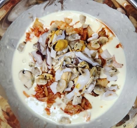 반죽에 잘게 썬 신김치 320그램과 해동한 모듬해물을 넣고 골고루 섞습니다. 부침가루에 간이 되어 있으므로 추가적인 간은 필요하지 않습니다.