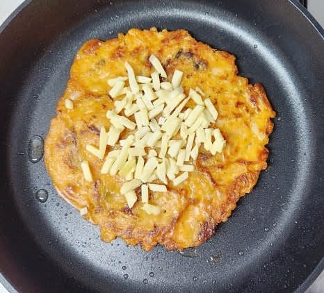 한쪽 면이 익으면 뒤집어서 반대쪽도 바삭하게 익혀줍니다. 뒤집은 직후 피자치즈 한 줌을 올려줍니다.