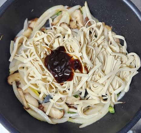 야채가 적당히 볶아지면 두부면을 넣고, 굴소스 2 큰술과 설탕 1 큰술을 넣어 잘 섞으며 볶아줍니다. 필요 시 물을 약간 추가합니다.