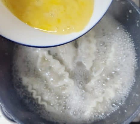 만두가 익으면, 풀어놓은 계란을 천천히 부어줍니다. 바로 저으면 국물이 탁해질 수 있으므로 잠시 기다렸다가 저어줍니다.