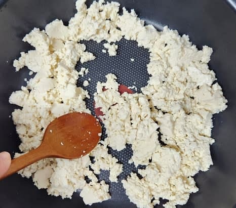 팬에 으깬 두부를 넣고, 들기름 1 큰술을 추가하여 센 불에서 2~3분간 볶아 물기를 제거합니다.