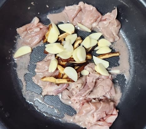 편썬 마늘과 얇게 썬 표고버섯을 팬에 추가하고 함께 볶아줍니다.