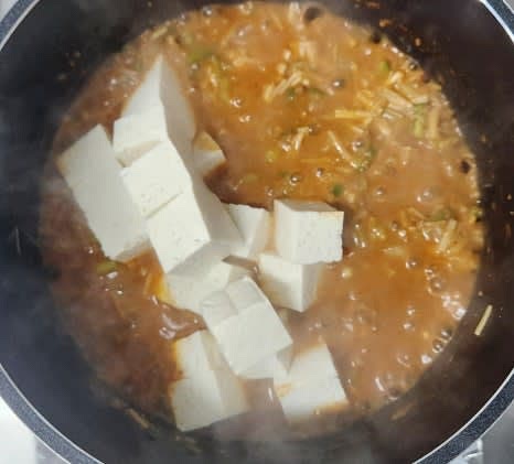 두부를 넣고 쪽파를 추가한 후 한 차례 더 끓여줍니다. 이때 두부는 주걱으로 살짝 으깨줍니다.