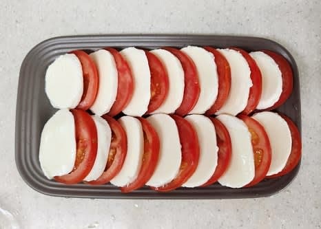 접시에 토마토와 모짜렐라 치즈를 번갈아 가며 겹쳐서 올립니다.