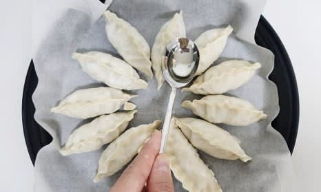 에어프라이어용 그릇에 종이호일을 깔고 냉동만두 12개를 올린 후, 식용유를 골고루 발라줍니다.