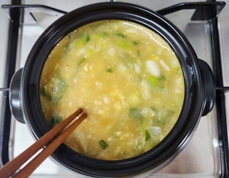 계란이 끓어오르기 시작하면 참기름 0.5 큰술을 넣고, 불을 약불로 줄인 후 젓가락으로 계속 저어줍니다. 계란이 약 70% 정도 익을 때까지 저어주세요.