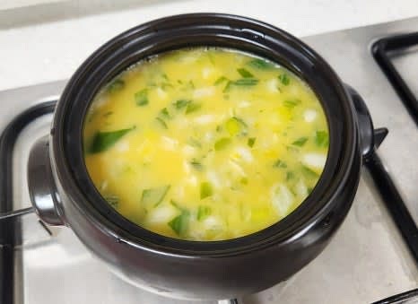 가스레인지에 뚝배기를 올리고, 중불에서 계란이 살짝 끓어오를 때까지 저어줍니다.