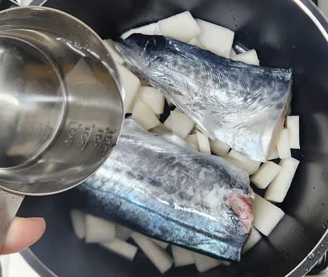 물 100ml를 냄비에 붓고, 준비한 양념장을 삼치와 무 위에 골고루 뿌립니다.