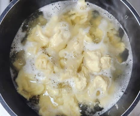 육수가 우러나면 육수팩을 제거하고, 약불로 줄인 후 감자를 먼저 넣습니다. 이어서 수제비 반죽을 손으로 뜯어 넣고, 불을 센 불로 올려줍니다.