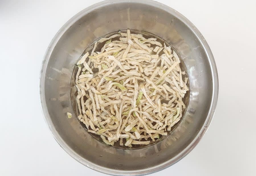 무말랭이 100g을 큰 볼에 담고, 뜨거운 물을 부어 약 15분간 불립니다.