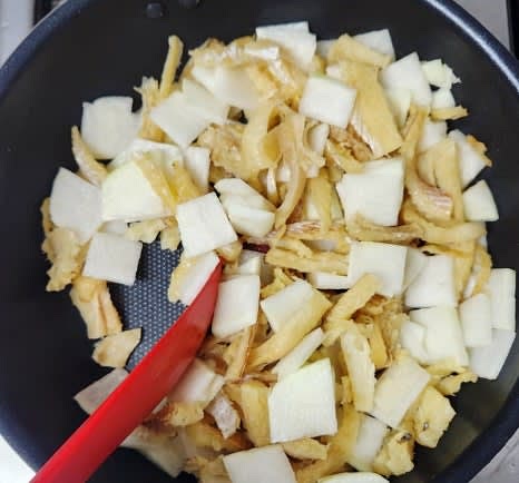 냄비에 무와 황태를 넣고, 참기름 2 큰술을 추가하여 센 불에서 2~3분 정도 볶아줍니다.