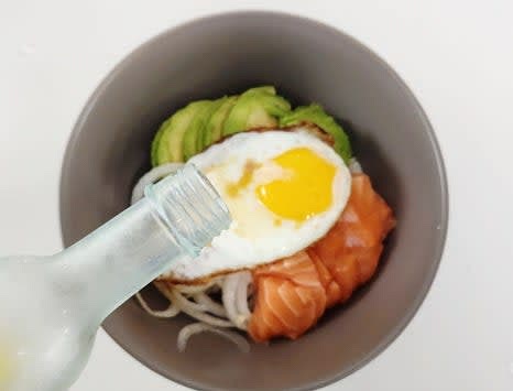 반숙 계란을 덮밥 위에 올리고, 쯔유 1.5 큰술과 참기름 1 큰술을 뿌립니다.