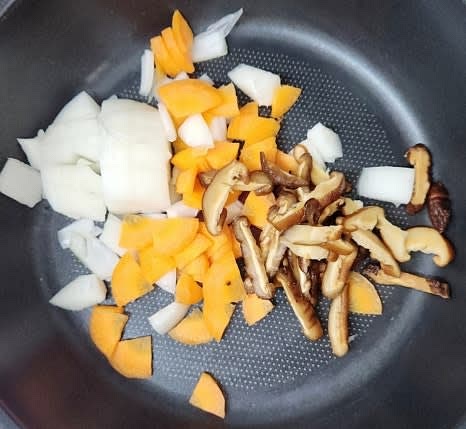 팬에 당근, 양파, 표고버섯, 다진 마늘 1 큰술을 넣고 식용유 1 큰술을 두른 후 센 불에서 살짝 볶습니다.