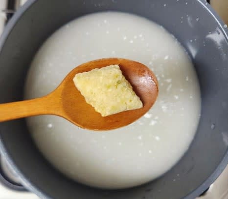 사골육수 500g을 냄비에 넣고, 다진마늘 1 큰술을 추가하여 센 불에서 끓입니다.