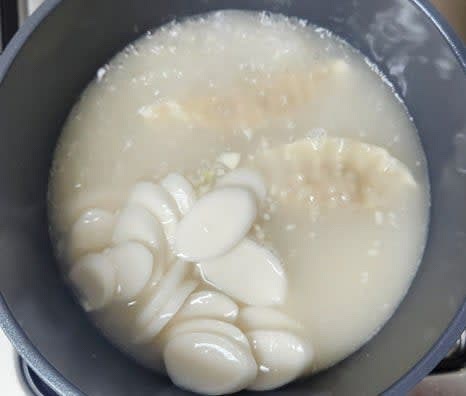 만두가 반투명하게 익어갈 때쯤, 불린 떡국떡을 깨끗이 헹궈 냄비에 넣습니다.