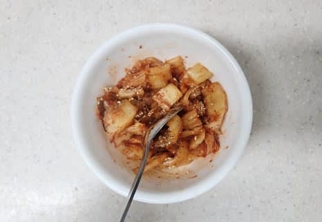 신김치 1/4포기를 잘게 썰고, 설탕 1/3 큰술, 참기름 0.5 큰술, 깨소금 0.5 큰술, 후춧가루 약간을 넣어 양념을 골고루 섞어줍니다.