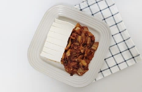 접시에 데친 두부와 볶은 김치를 함께 담아냅니다.