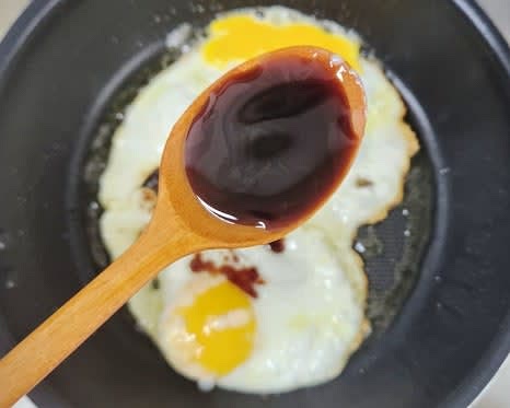 계란이 반숙 정도로 익으면 불을 약하게 줄이고, 양조간장 0.5 큰술을 팬 가장자리에 둘러줍니다.