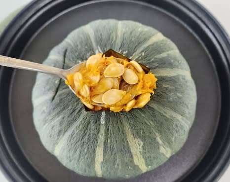 가열된 단호박의 윗부분을 잘라 뚜껑을 만들고, 속의 씨를 조심스럽게 제거합니다.