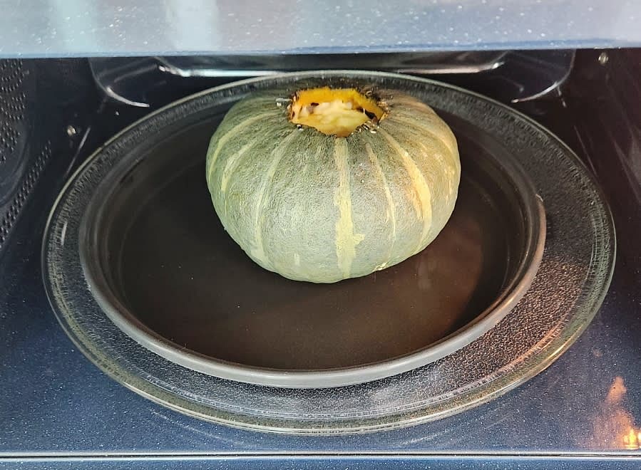 단호박을 전자레인지에 넣고 약 5분간 가열하여 치즈를 녹입니다.