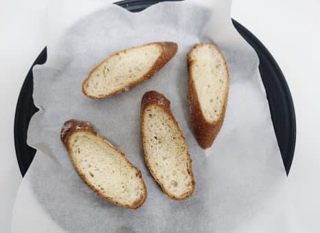 에어프라이어용 팬에 종이호일을 깔고, 그 위에 바게트빵 4조각을 올립니다.