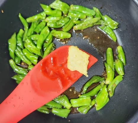 다진 마늘 0.5 큰술을 추가한 후, 중불에서 꽈리고추가 적당히 익을 때까지 볶아줍니다. 필요 시 물을 조금씩 추가하여 조리합니다.