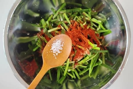 큰 볼에 썰어놓은 부추를 넣고, 고춧가루 3 큰술, 설탕 1.5 큰술, 소금 2/3 작은술을 넣어줍니다.