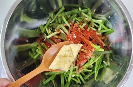 다진 마늘 1 큰술, 액젓 1.5 큰술, 식초 2 큰술, 참기름 1 큰술을 추가합니다.