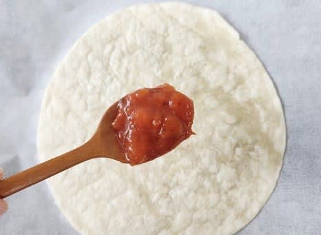 또띠아 1장에 토마토소스 3 큰술을 골고루 바릅니다.
