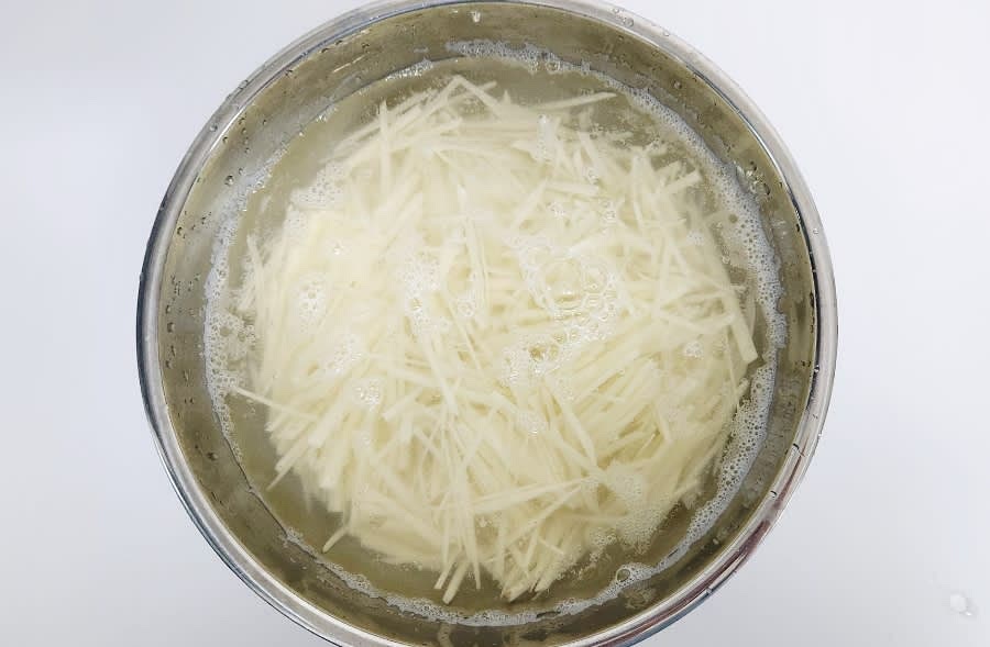 채 썬 감자를 물에 10분 이상 담가 전분기를 제거한 후, 물기를 빼줍니다.