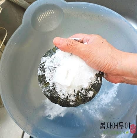 단호박을 베이킹파우더로 박박 문질러서 세척해요. 전자레인지에 2분 돌린 후 윗부분을 뚜껑처럼 잘라내고 속의 씨를 제거합니다.