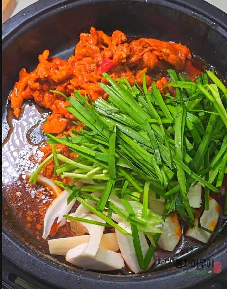 오리고기가 반쯤 익으면 양파와 버섯을 넣고 볶다가 부추를 넣고 불을 줄여줍니다.