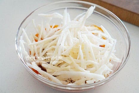 손질한 더덕을 넣고 빨간색 양념이 어우러질 수 있도록 무칩니다. 조물조물 버무리면서 결대로 찢은 사이사이로 간이 뱁니다. 쪽파와 통깨를 넣고 버무려 마무리합니다. 간이 약간 부족해서 소금 한 꼬집 더했습니다.