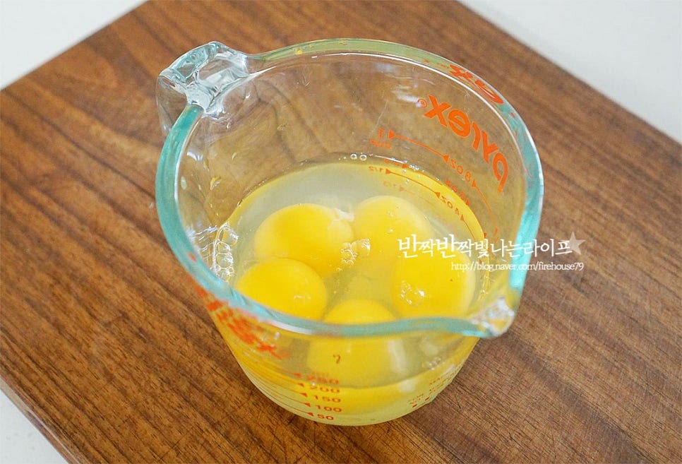 달걀을 볼에 깨뜨려 넣어준 뒤 맛술 1 작은 술, 소금 1/4 작은 술 넣어줍니다. 계란은 크기에 따라 4~5개 넣어주시면 되는데요. 저는 4개 + 노른자 1개 넣어주었습니다. 노른자를 하나 더 넣어 노란 색감을 살려주었어요~ 곱게 잘 풀어줍니다. 체에 한번 내려주시면 더 부드럽게 만들어 드실 수 있어요. 달군 팬에 식용유를 얇고 고르게 둘러준 뒤 프라이팬에 얇게 부어줍니다. 길이가 긴 것이라 동그란 팬에 구웠는데 짧은 사이즈는 네모난 계란말이 팬에 구워도 좋아요. 가장자리가 반 정도 익으면 데친 소시지를 올려줍니다. 약불에서 천천히 말아줍니다. 처음 모양이 잘 고정되어야 잘 말아지므로 처음엔 약불로 익으면서 고정될 수 있게 해줍니다. 약불로 굴려가며 말아줍니다. 계란말이 하듯이 해주시면 되어요. 속까지 굴려가며 익혀준 뒤 한 김 식혀 모양을 고정시켜 줍니다.