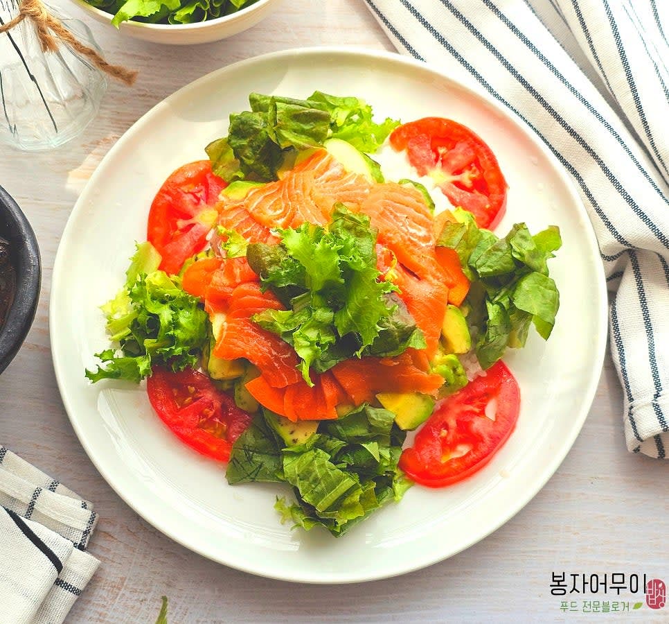 밥 위에 아보카도와 연어를 얹고, 준비된 야채와 사케동 소스를 곁들여 완성합니다.