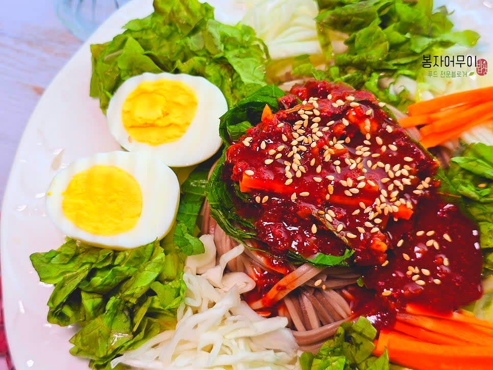 큰 접시에 삶은 메밀면을 올리고 준비한 채소와 삶은 계란을 올립니다.