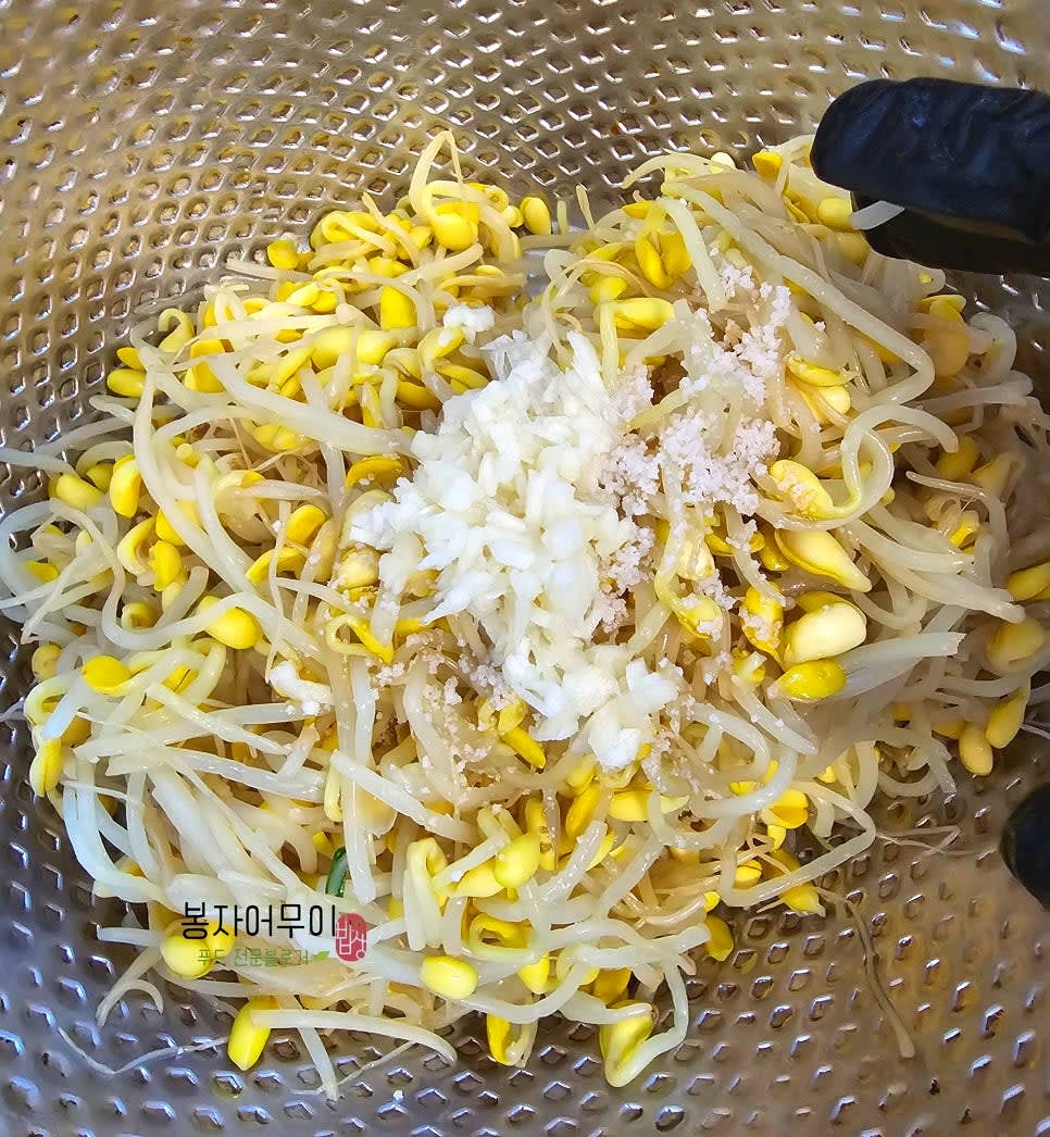 삶은 콩나물에 다진 마늘 1스푼, 소금 1스푼, 참기름 1스푼을 넣고 잘 무칩니다.